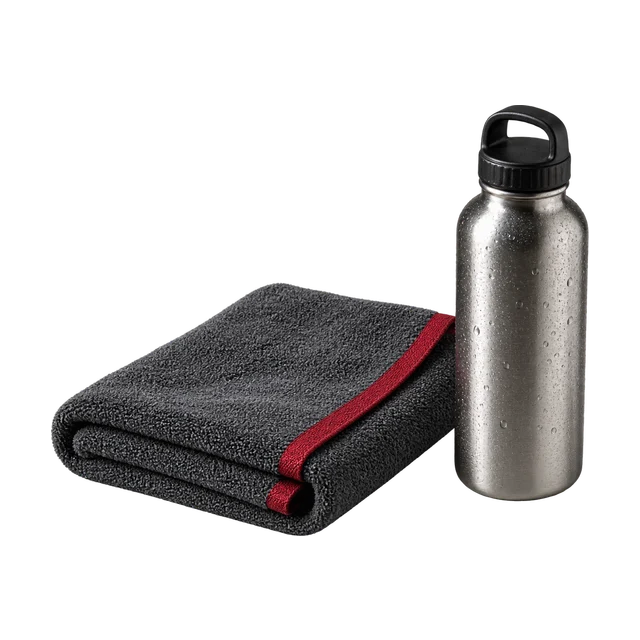 Een opgevouwen handdoek met rood randje naast een stalen bidon