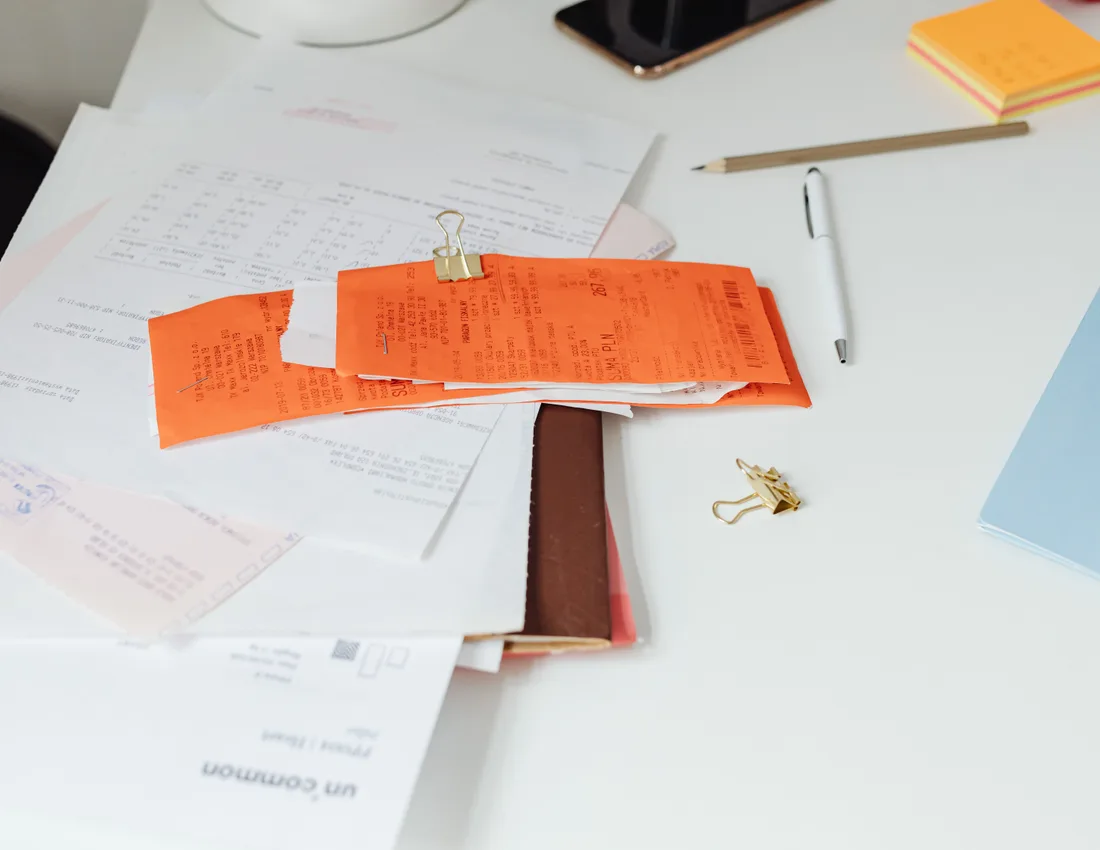Stapel bonnetjes en facturen met paperclip op een bureau