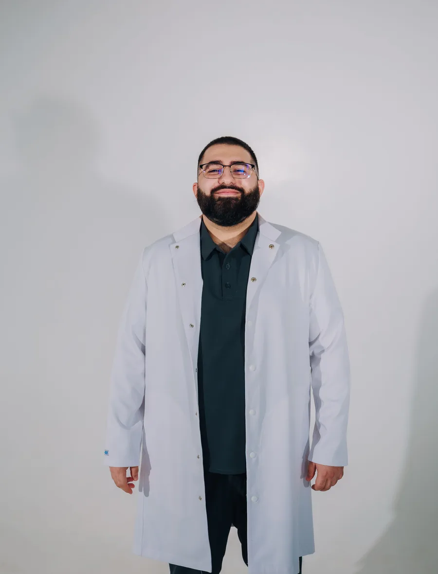 Portret van een lachende apotheker in een witte jas
