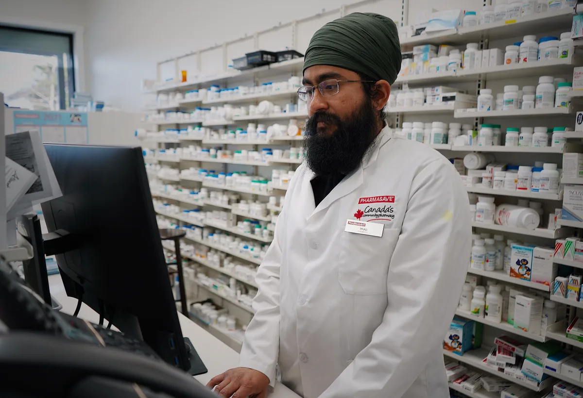 Apotheker bespreekt medicatieoverzicht aan balie met cliënt
