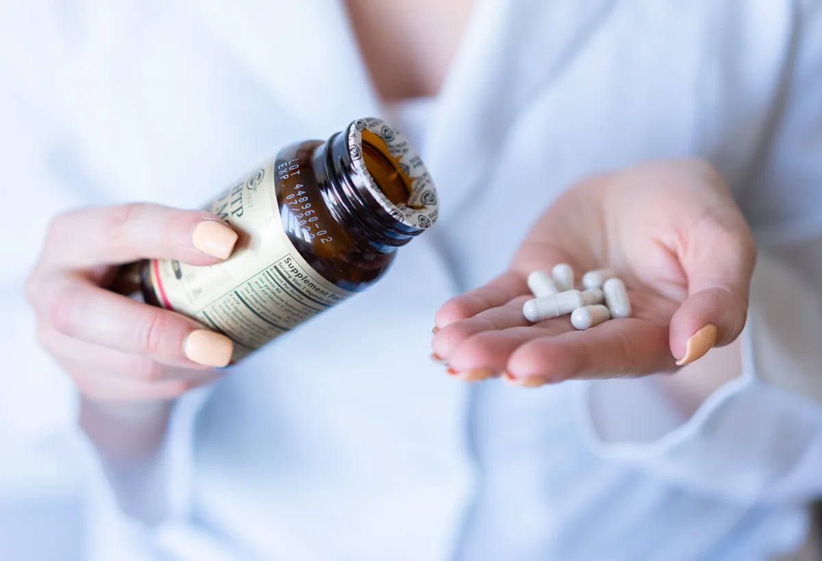 Flesje vitamine D druppels met maatlepel en capsules