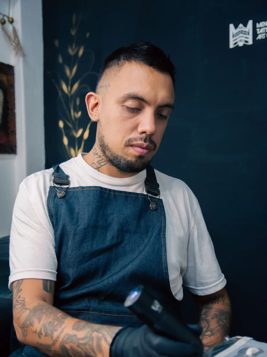 Barbier Ruben in de zaak, met schort en tatoeages