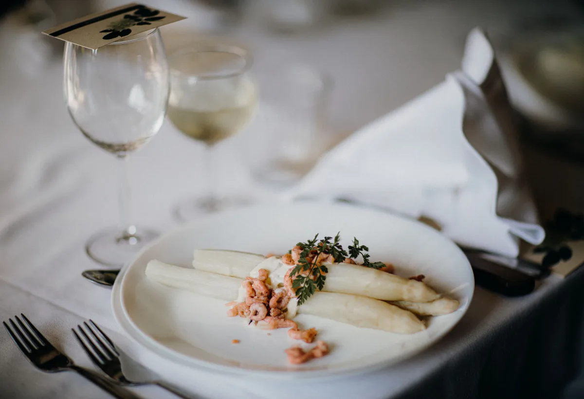 Verse witte asperges en lentegroenten op snijplank