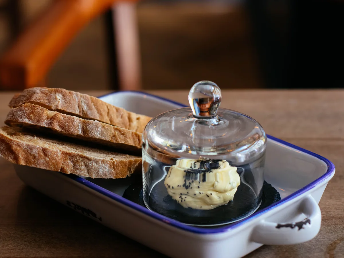 Brood met kruidenboter onder een glazen stolp