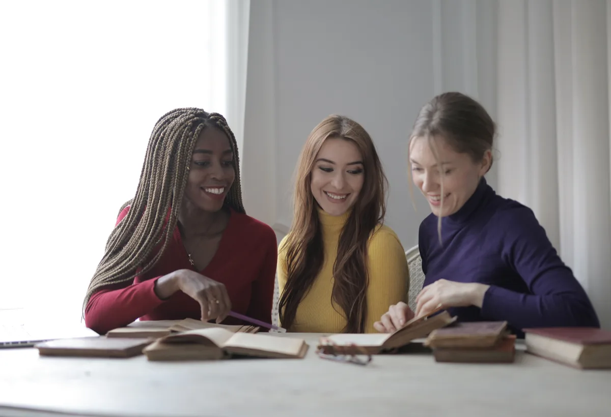 Vrienden bespreken een roman met koffie aan houten leestafel