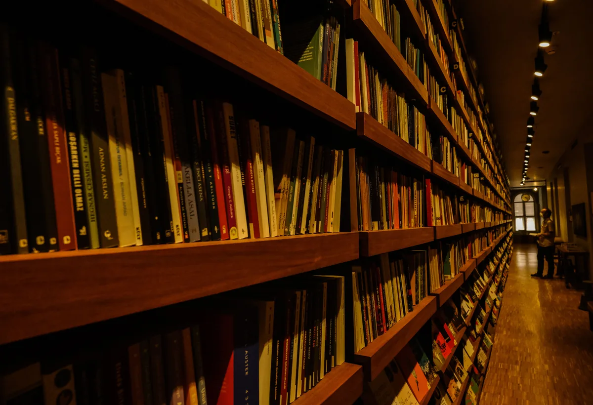 Hoge houten boekenkasten gevuld met literatuur en poëzie