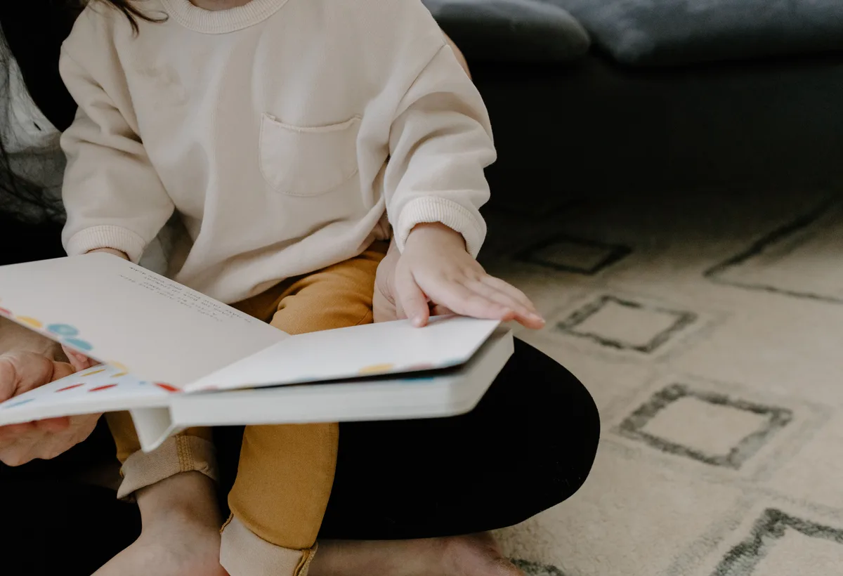 Ouder leest prentenboek voor aan kind voor het slapengaan