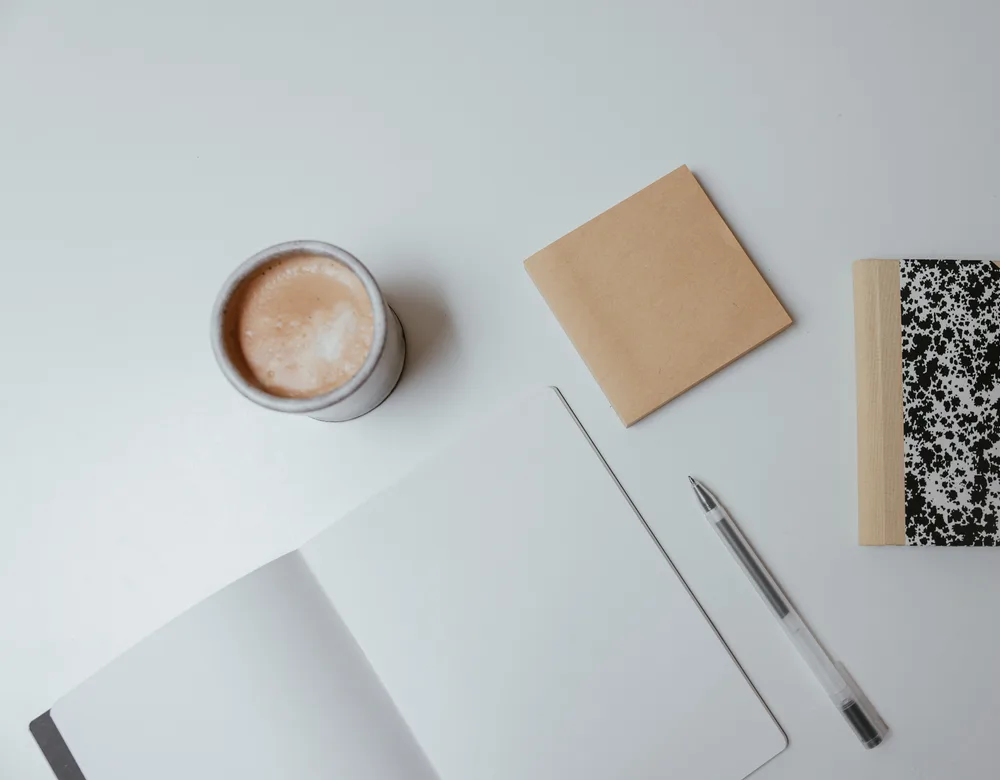 Leeg notitieboek met pen en koffie op een rustig bureau