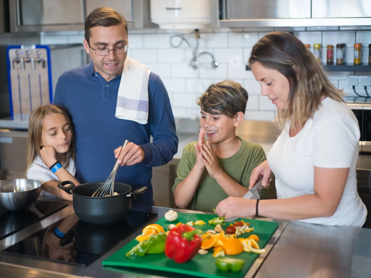 Gezin kookt samen met groente in de keuken