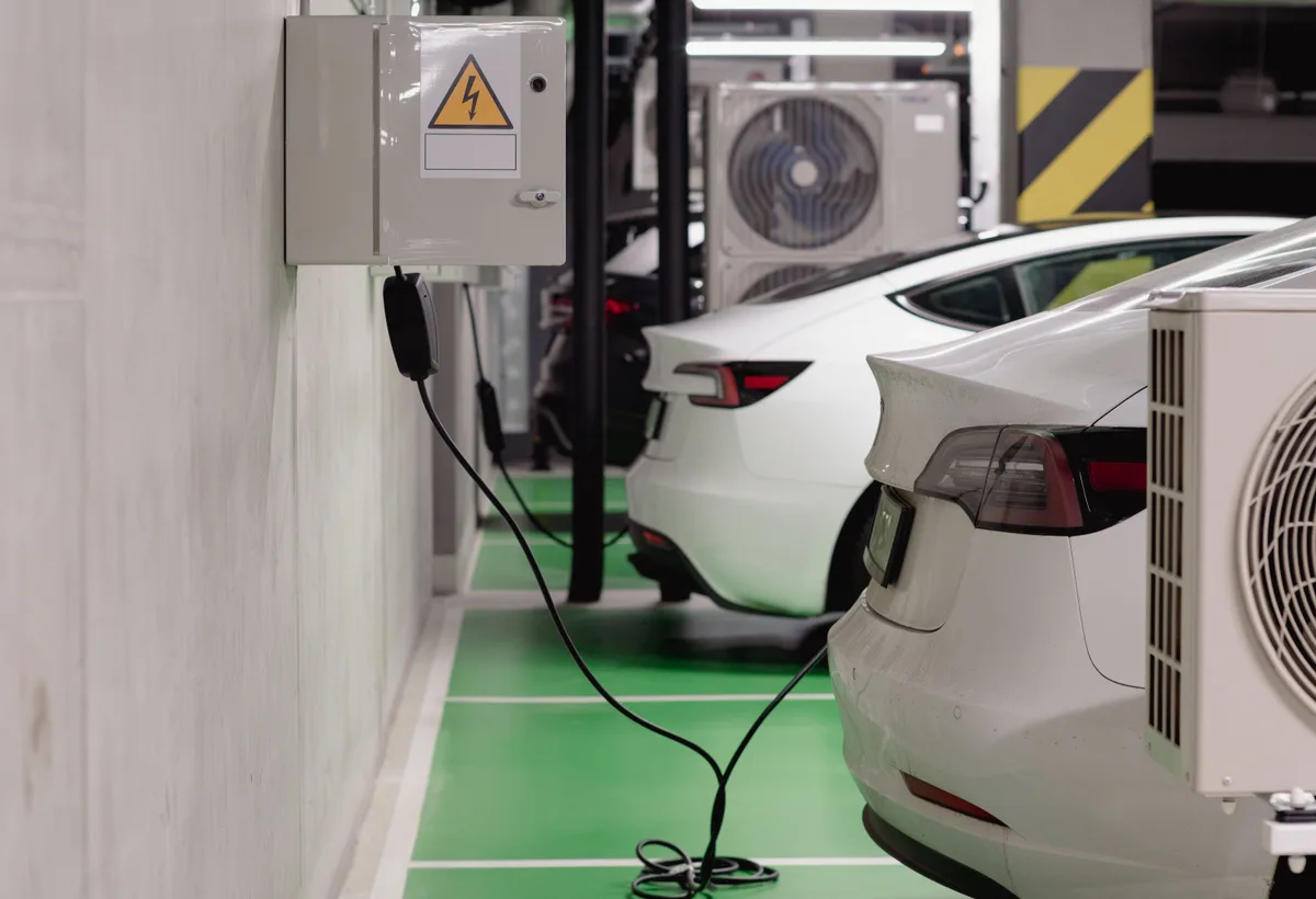 Wandlaadpaal aangesloten op elektrische auto bij oprit