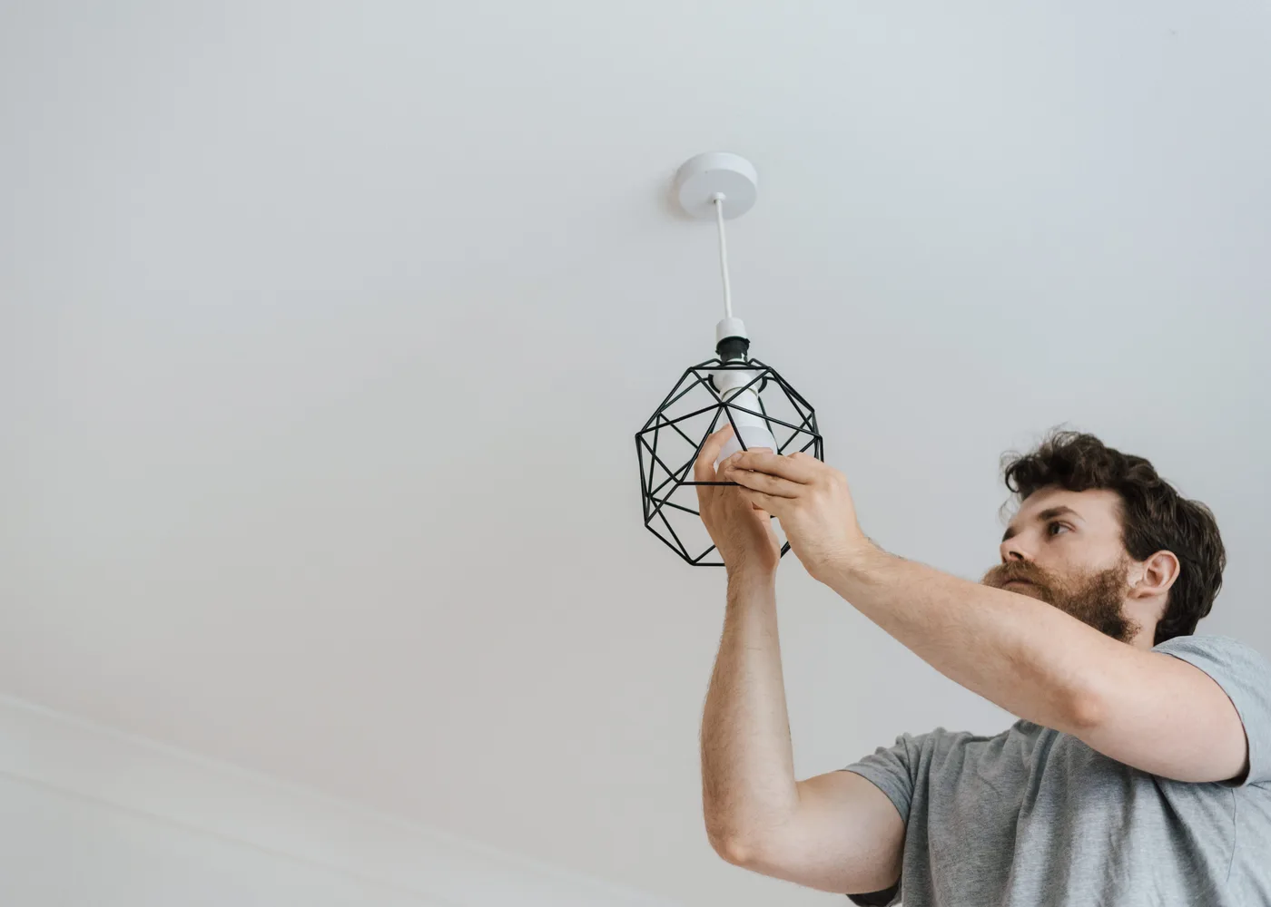Monteur hangt een armatuur aan het plafond