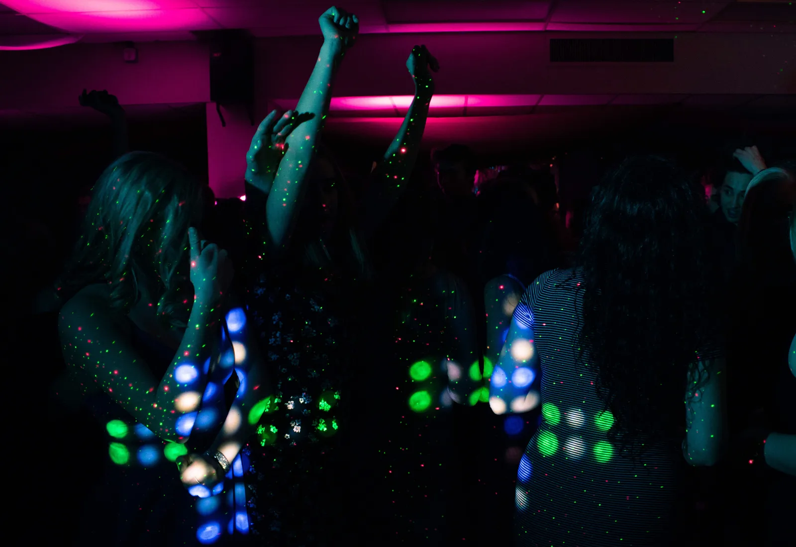 Dansende gasten onder gekleurd licht