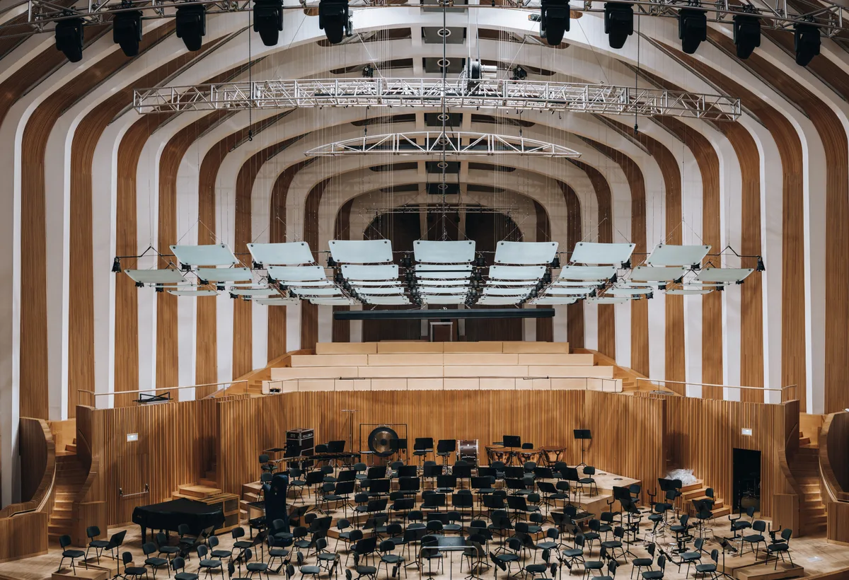 Spreker op podium met professioneel line-array audiosysteem