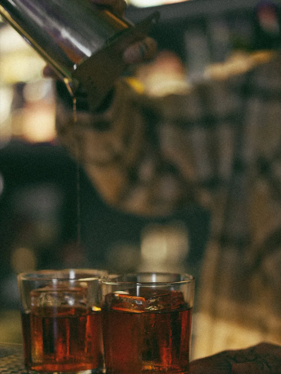 Barman schenkt cocktails uit aan de bar