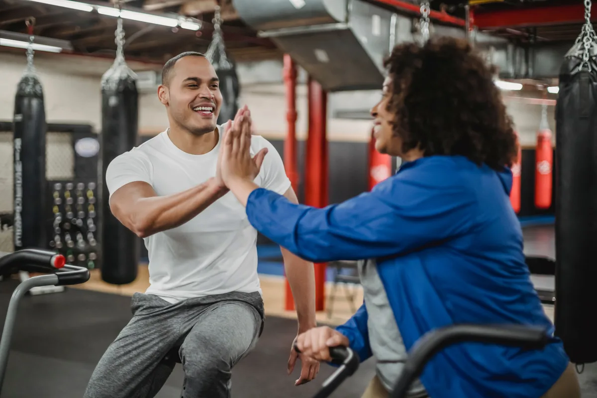 Twee leden geven elkaar lachend een high five na een training