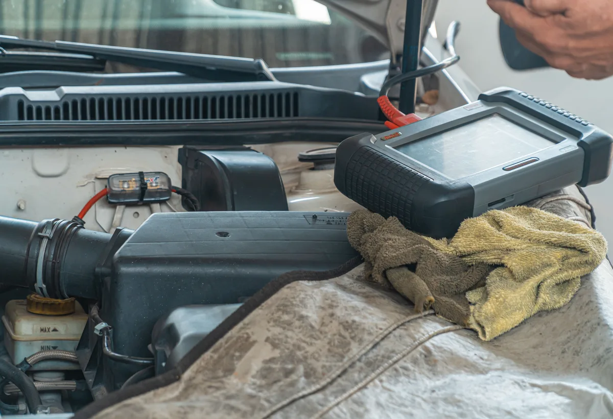 Diagnosetester aangesloten op OBD2 poort in auto
