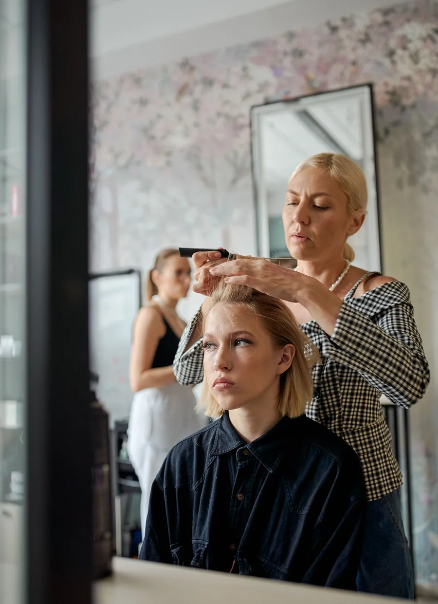 Stylist zet het kapsel af voor de spiegel
