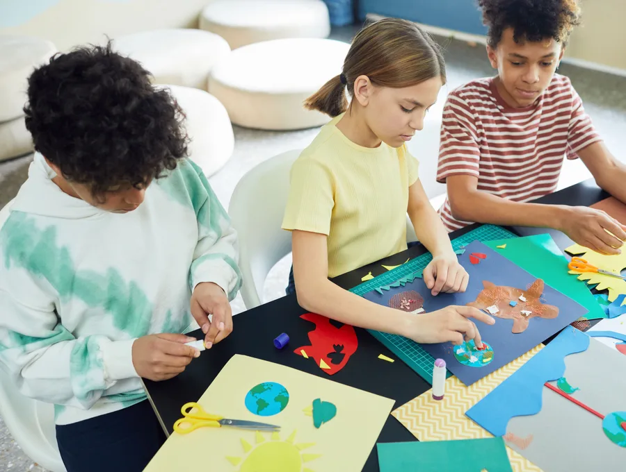 Schoolkinderen knutselen samen aan tafel