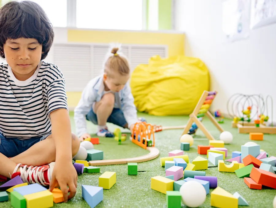 Peuters spelen samen met blokken in de groepsruimte