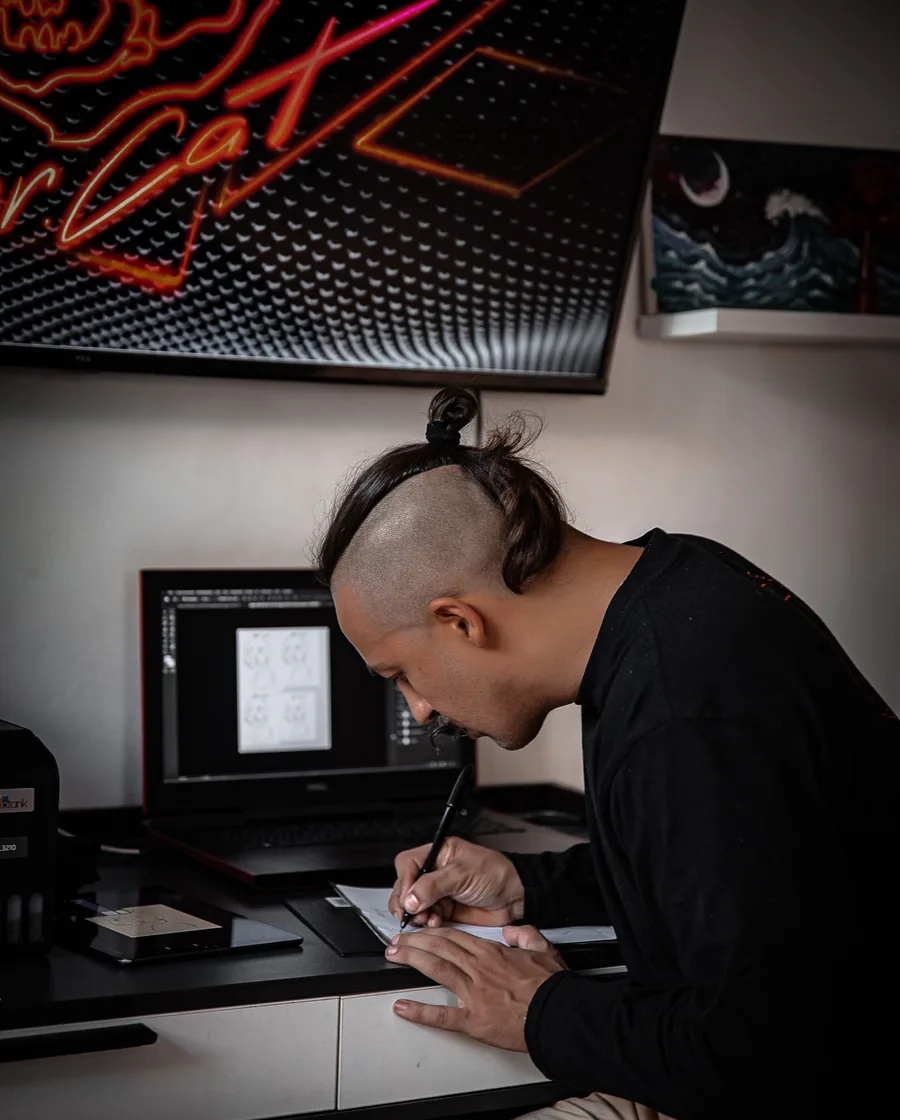 Ontwerper aan een bureau die schetst onder een neonbord