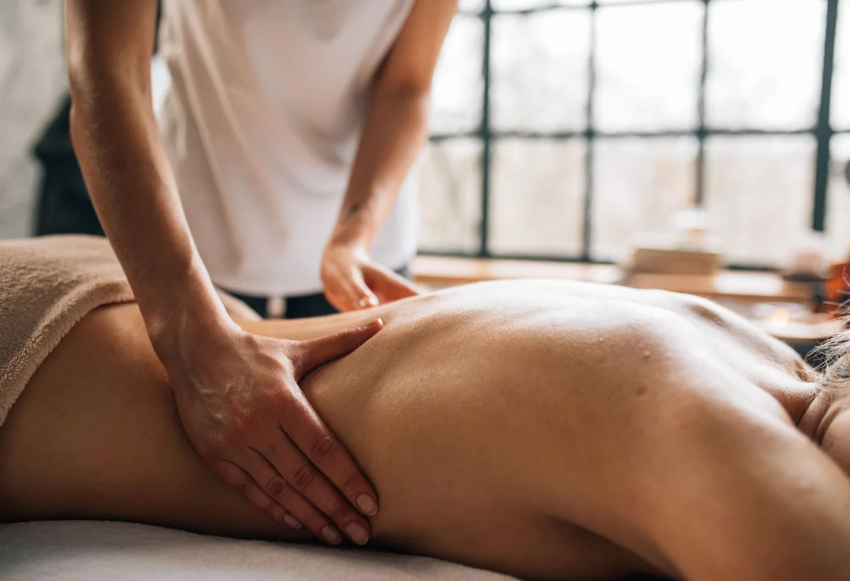 Massagetherapeut past stevige roltechniek toe op bindweefsel van de rug