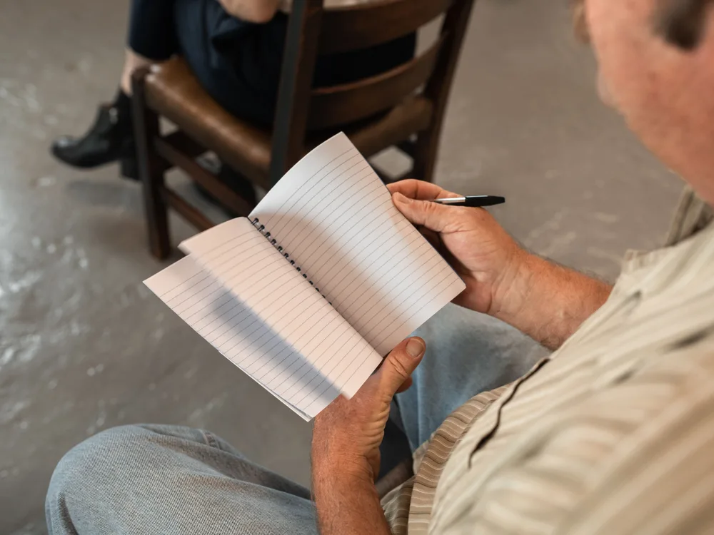Cursist schrijft aantekeningen in een notitieboek tijdens een les