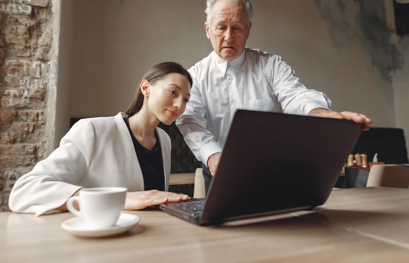 Docent begeleidt een cursist achter een laptop