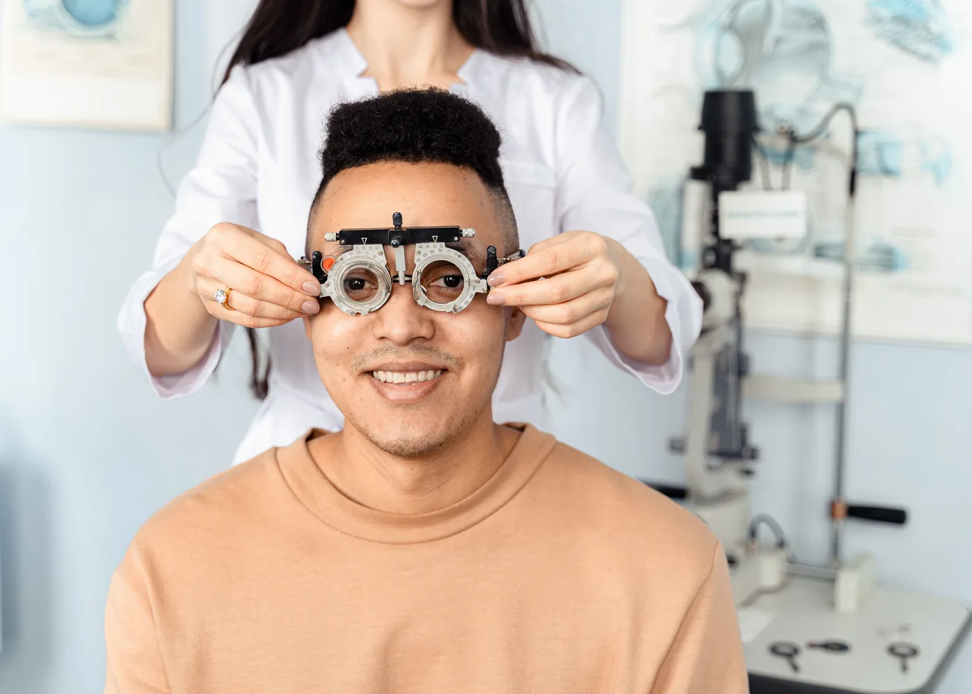 Opticien zet een pasmontuur op bij een lachende klant