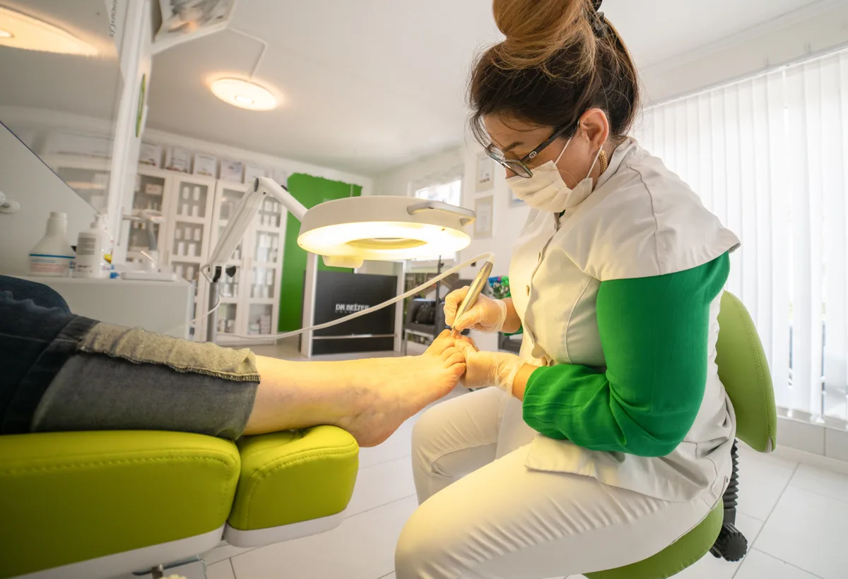 Pedicure verwijdert voorzichtig eeltkern met steriel mesje