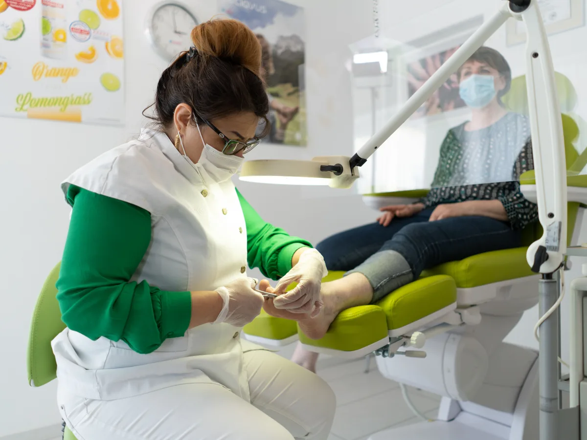 Medisch pedicure behandelt een voet met professioneel instrumentarium