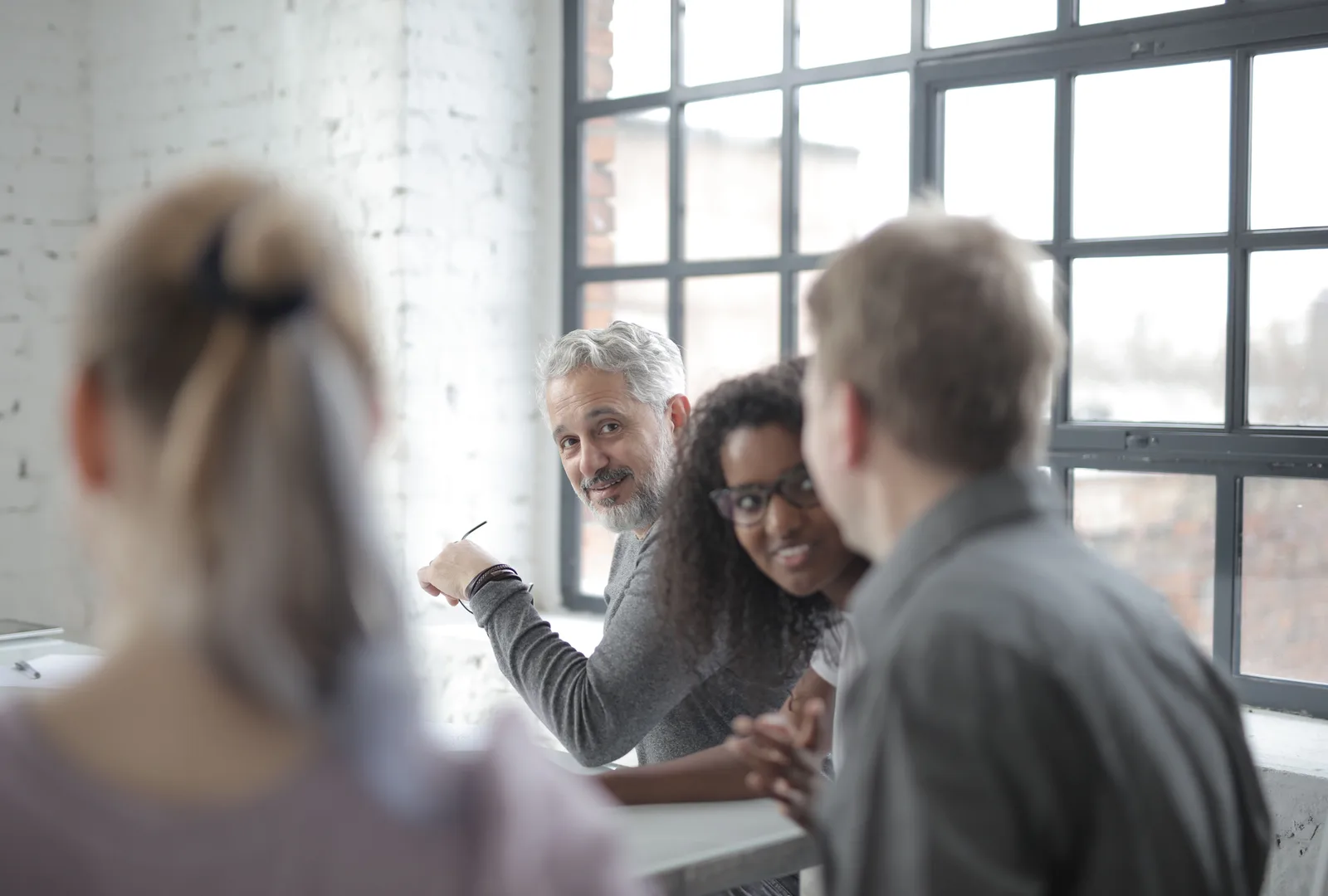Team en aannemende manager in gesprek in een licht kantoor