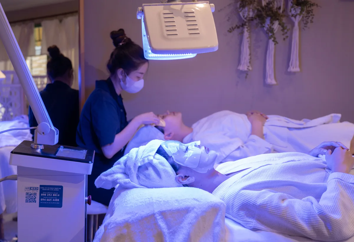 Schoonheidsspecialiste masseert gezicht met rozenkwarts Gua Sha steen