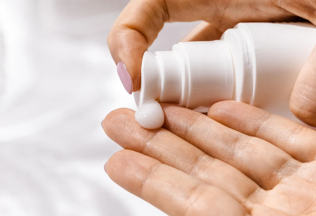 Zachte minerale zonnebrandcrème aangebracht op de handrug