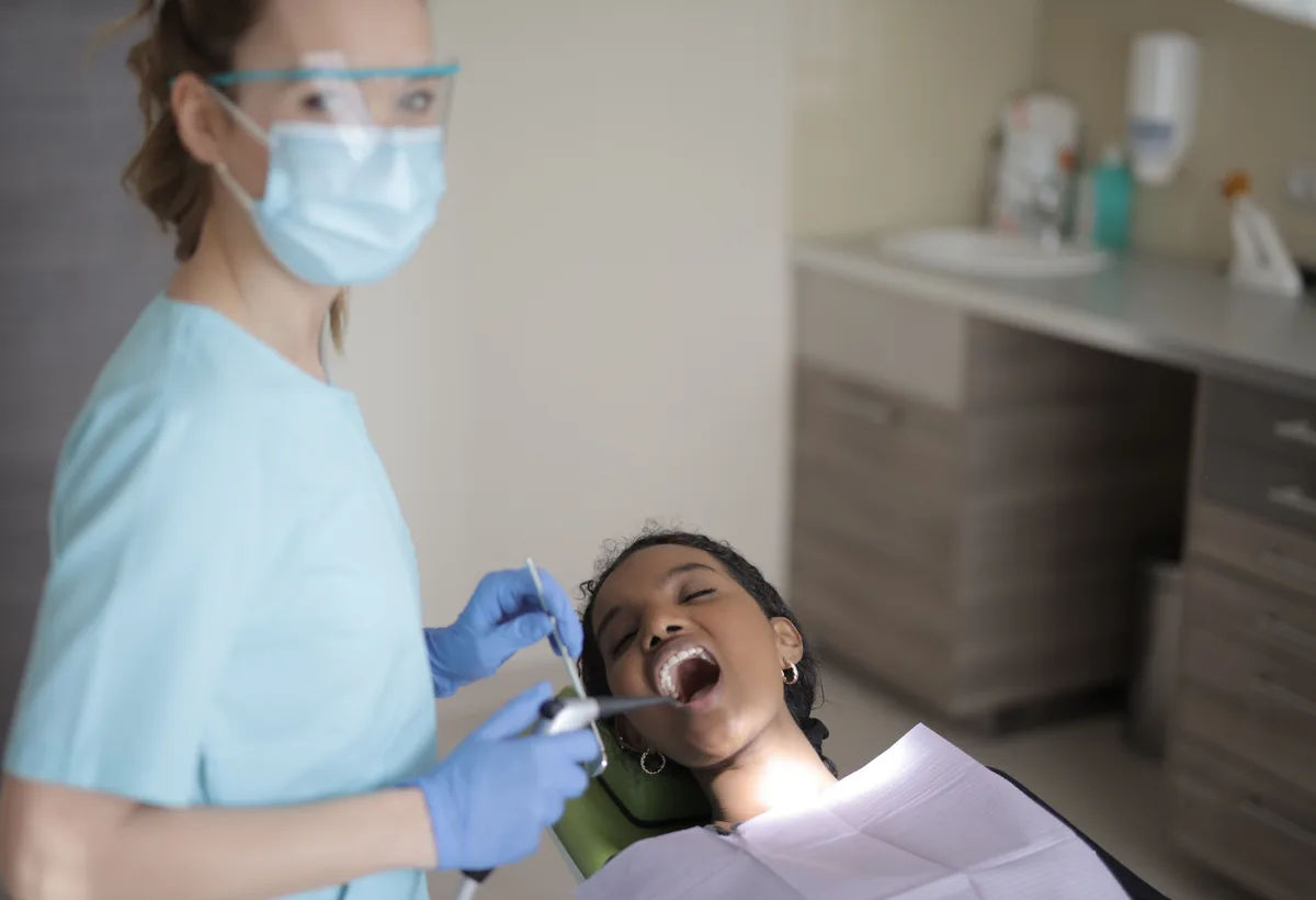 Mondhygiëniste reinigt pockets met zacht ultrasoon instrument