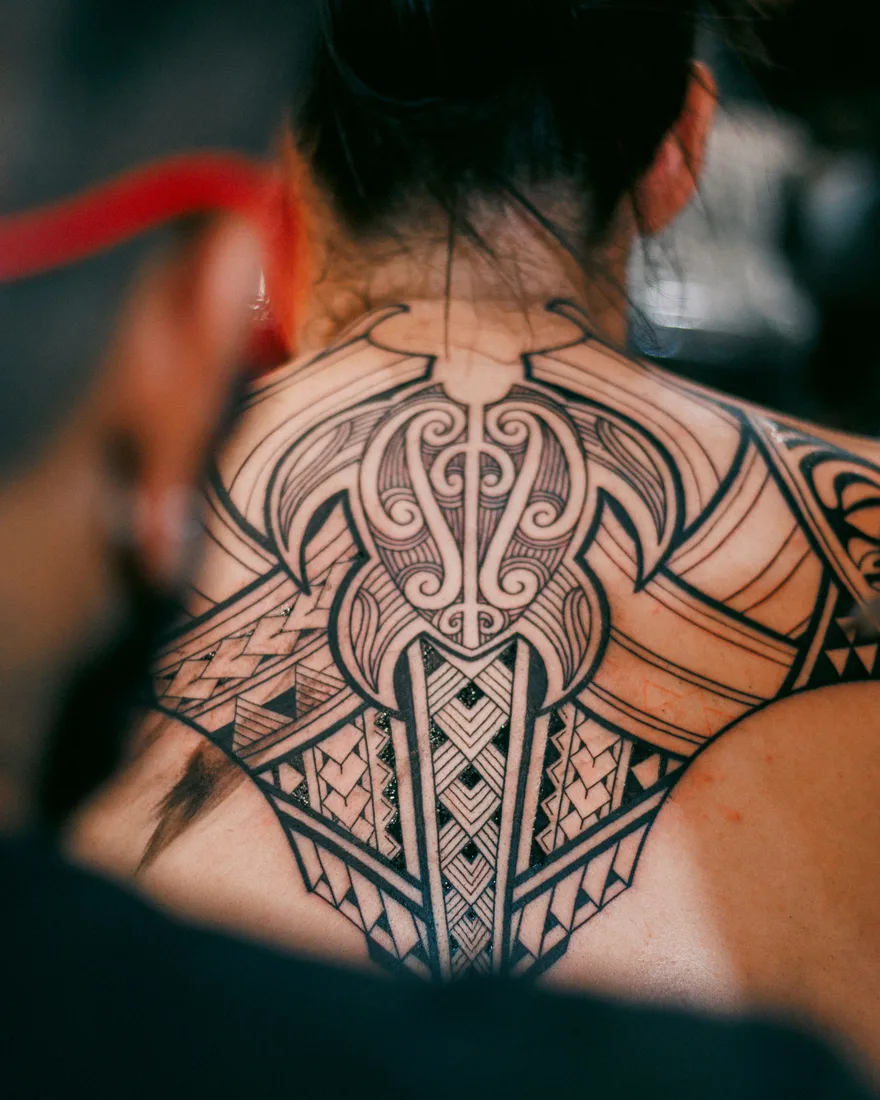 Ornamentele blackwork-tattoo met geometrische patronen op nek en rug