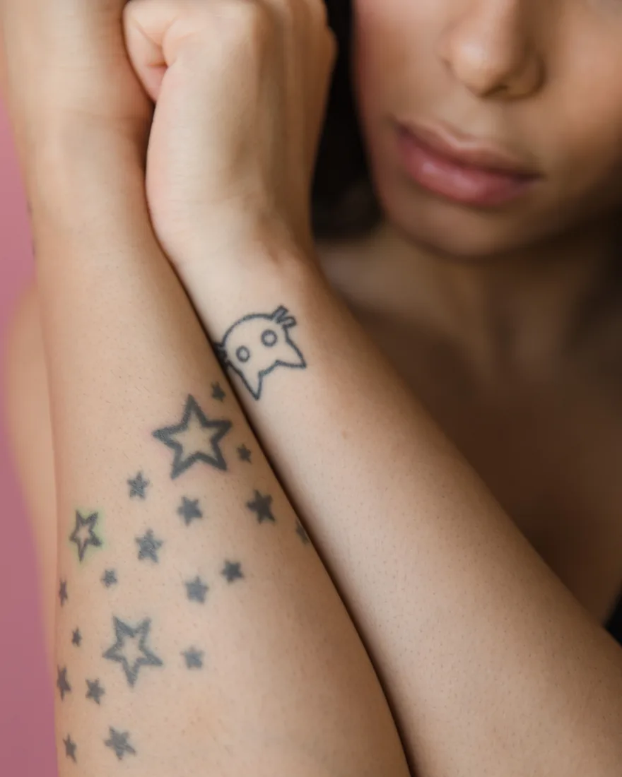 Kleine fine line tattoos van sterren op een onderarm