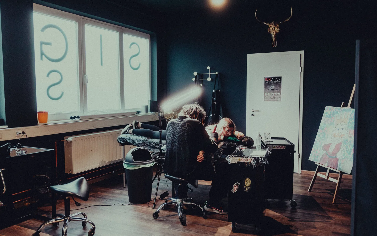 Interieur van het tattoo-atelier met behandelstoel en werklamp