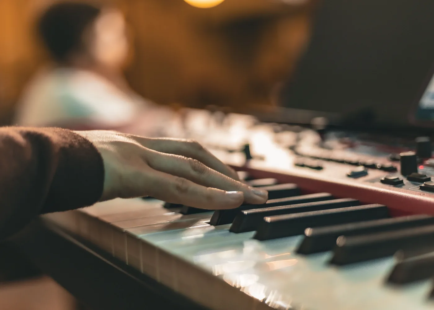 Handen die zacht piano spelen in warm licht