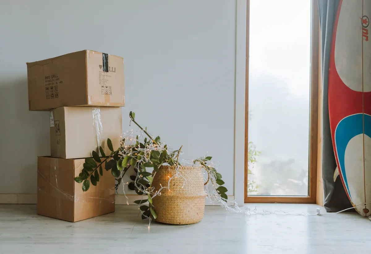 Familie plakt labels op stevige kartonnen verhuisdozen in woonkamer
