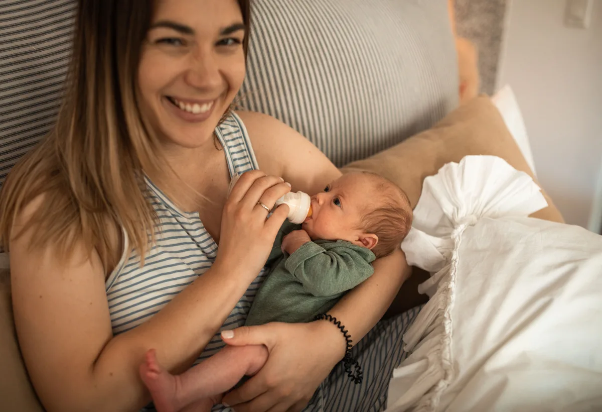 Moeder houdt pasgeboren baby tegen borst met ondersteuning van kraamverzorgster