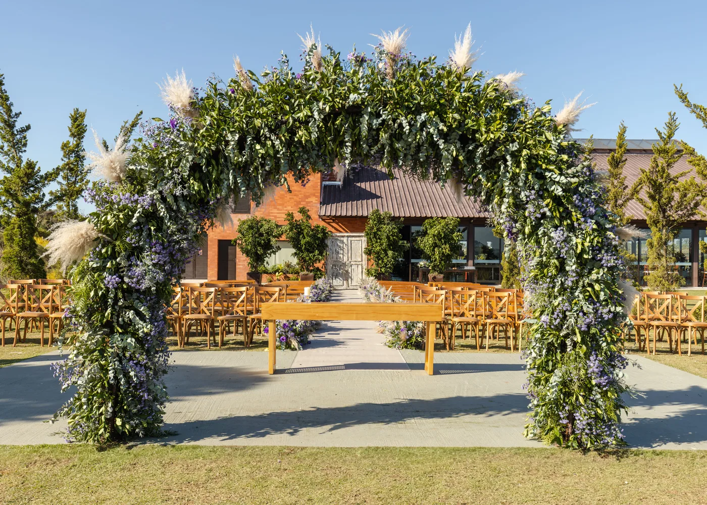 Buitenlocatie met bloemenboog klaar voor de ceremonie
