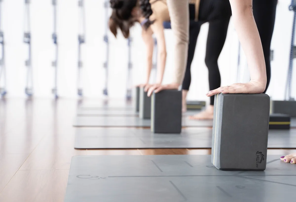 Stapel kurken yogablokken, katoenen riem en wollen yogadeken
