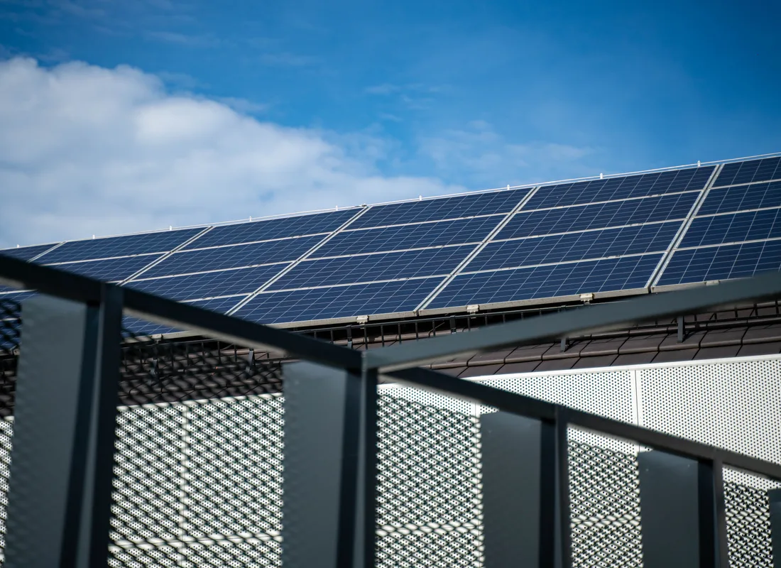 Zonnepanelen opgesteld op een plat dak tegen een blauwe lucht