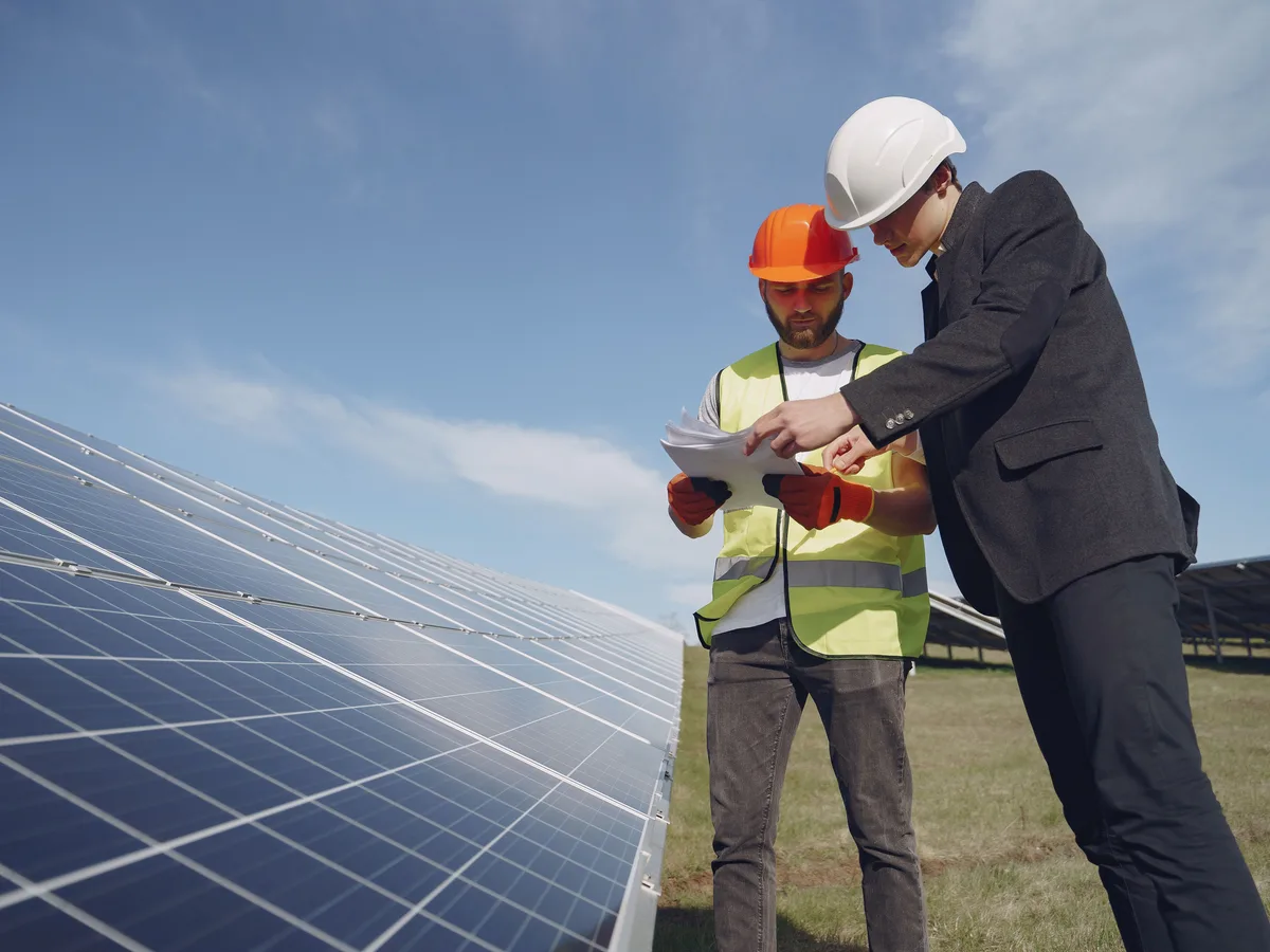 Schouwer en monteur nemen samen het legplan door bij de zonnepanelen